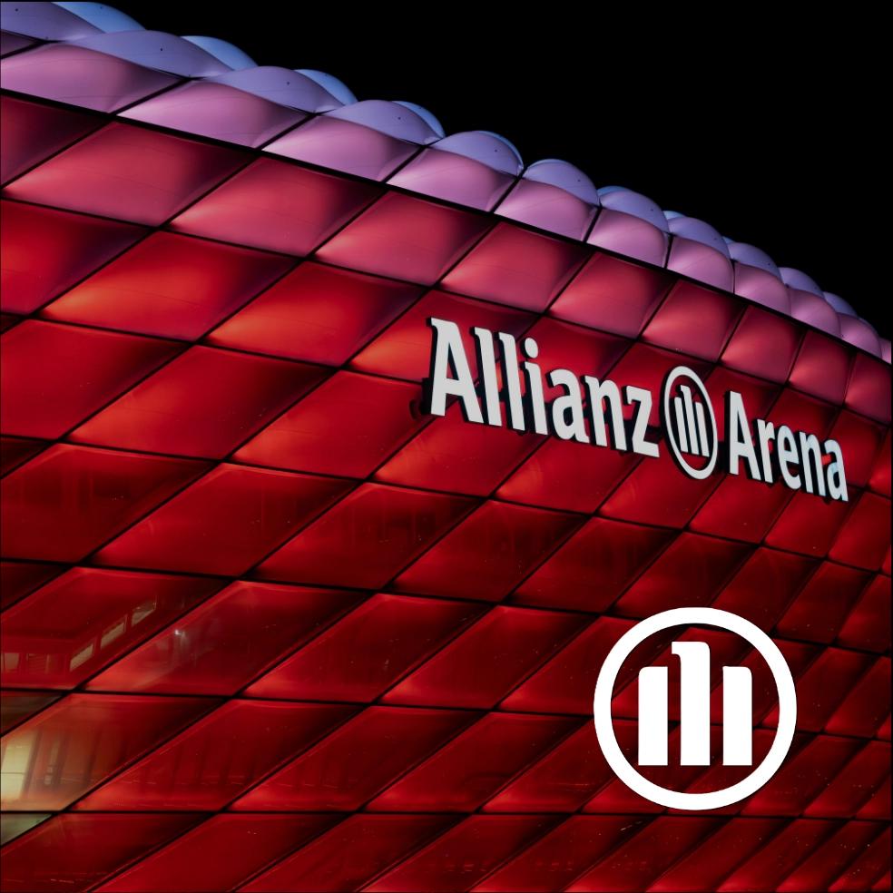Nachtaufnahme der Allianz-Arena, im Vordergrund liegt das Logo von Allianz.